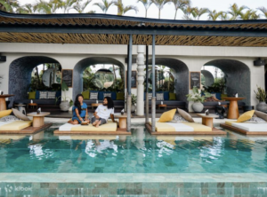 people sitting by pool relaxing at a music and wellness retreat